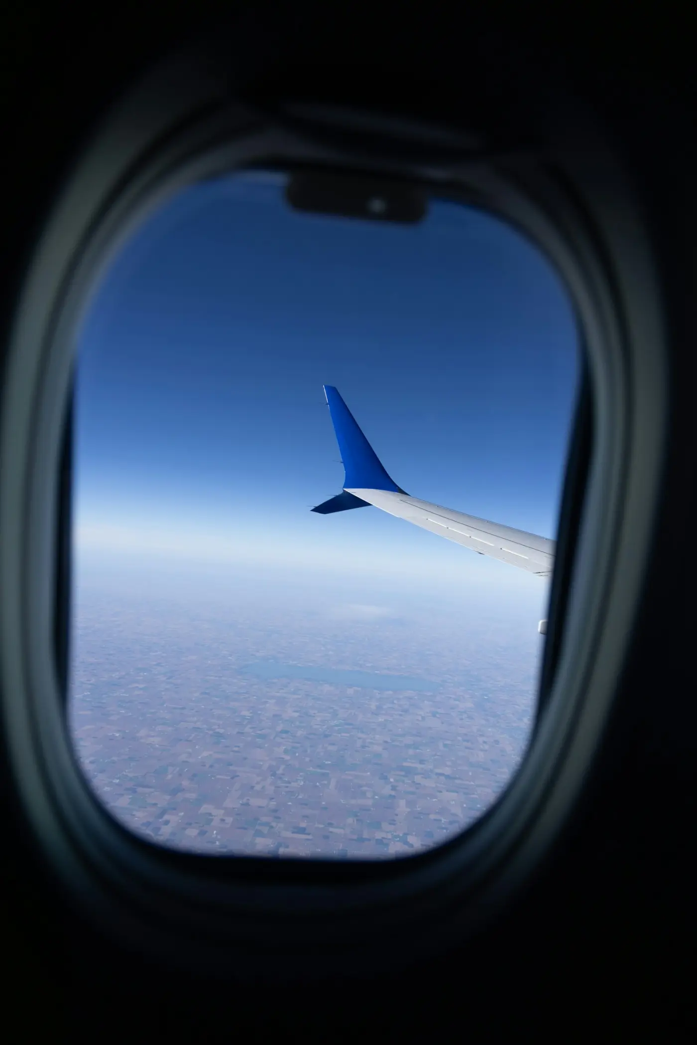 An aircraft wing above cloud, seen from a window